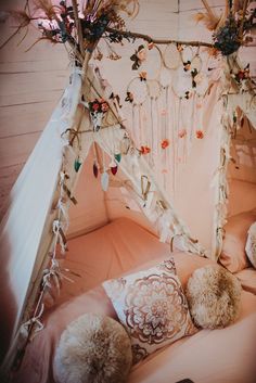 a canopy bed with pillows and decorations on it