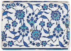 a blue and white tile with floral designs on it's sides, in the shape of flowers