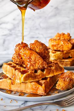 a plate topped with waffles covered in syrup and being drizzled