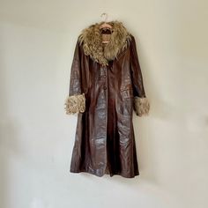 Vintage 1970s boho style chocolate brown leather coat with light brown natural fur collar and cuffs, which I believe could be Angora goat. Three button front closure, with 2 flap closure front pockets. A similar coat was worn by Kate Hudson as Penny Lane in the popular Almost Famous movie. Quilted lining with interior sewn in label for cleaning purposes.  Brand:  Unknown Color: Brown / Beige Circa:  70's Condition:  Very Good/Good Vintage Condition - Some Signs Of Wear With Scuffs & Scratches On Leather.  No Size Indicated ~ Please see measurements below. Would Work Well For Size Small - Medium and Possibly Large Made From Leather Angora Goat Fur Trim Long Sleeves With Fur Cuffs Wide Fur Collar Front Button Closoure Below The Knee Length Quilted Lined Interior Approximate Measurements:  40 Almost Famous Movie, Brown Leather Coat, Penny Lane Coat, Fur Trim Coat, Seventies Fashion, Penny Lane, Kate Hudson, Shearling Coat, Vintage Coat