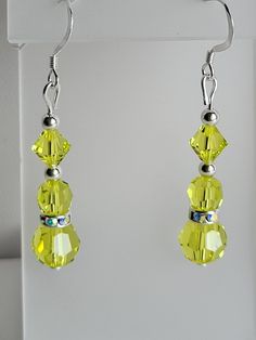 This pair of dangle earrings is made from Sterling Silver beads and findings including lever back ear wires and filigree bead caps. It contains an 4mm, 6mm and 8mm bright yellow-green colored Swarovski Citrus crystal. These earrings also feature clear ab Czech crystal rondelle beads. Custom Orders are always welcome! Yellow Dangle Earrings With Lever Back, Yellow Ceramics, Carnation Flower, Light Blue Green, Pink Ceramic, Czech Crystal, Bead Caps, Sterling Silver Bead, Sterling Earrings