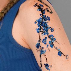 a woman's arm with blue flowers painted on it