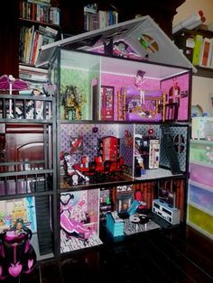 a doll house with lots of furniture and bookshelves on the shelves in front of it