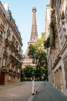 a person walking down a street in front of the eiffel tower