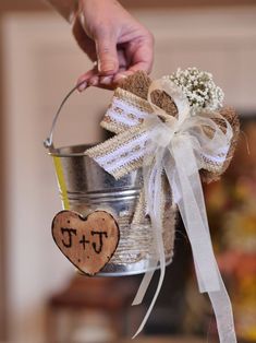 a person holding a tin can with a heart on it and a bow around the handle