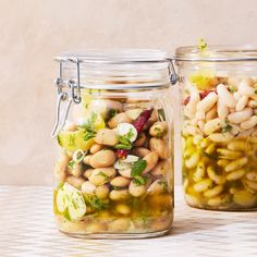 two jars filled with food sitting on top of a table