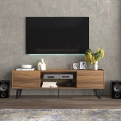 an entertainment center with speakers and a flat screen tv mounted on the wall above it