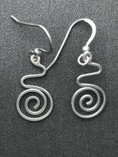 This Earring is a compliment to the Pendant with a similar name. They are amde from 1mm Sterling Silver wire. Formes into this shape using traditional Silversmithing techniques. Spiral Silver Plated Wire Earrings As Gift, Spiral-shaped Pierced Metal Jewelry, Artistic Spiral Nickel-free Jewelry, Spiral Silver-plated Wire Earrings, Nickel-free Silver Fish-shaped Earrings, Wire Earrings Handmade, Aluminum Jewelry, Wire Earrings, Silver Wire