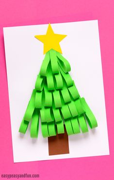 a christmas tree made out of green paper with a star on top, sitting on a pink background