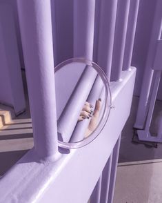 a person's reflection in a mirror on the side of a purple structure with columns