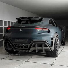 the rear end of a grey sports car in a garage with white tile flooring