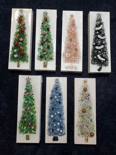 six small christmas trees are displayed in white boxes