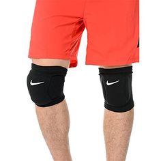 a man in red shorts and black knee pads is standing with his hands on his hips