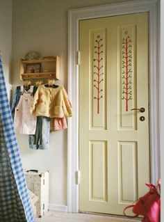 a child's room with clothes hanging on the wall and an open closet door