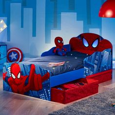 a child's bedroom decorated in blue and red with a spiderman theme on the bed