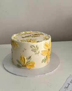 a white cake with yellow flowers on it