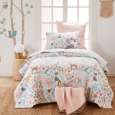 a bed in a room with a pink comforter and pillows on the floor next to a window