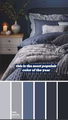 a bedroom with dark blue walls and grey bedding, white nightstands and candles