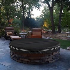 a fire pit surrounded by patio furniture and trees