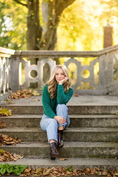 a woman sitting on some steps in the fall