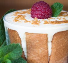 a cake with frosting and raspberries on top