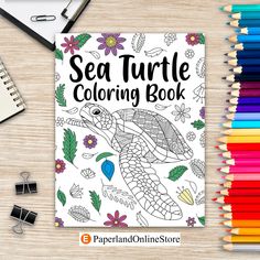 the sea turtle coloring book is next to colored pencils and markers on a table