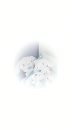 several stuffed animals sitting in the corner of a white room with light coming from behind them