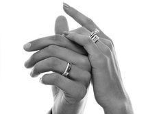 two hands holding each other with wedding rings on their fingers, in black and white