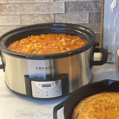 a crock pot with beans and bread in it on a counter next to a toaster