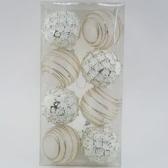 a clear box filled with white and gold ornaments