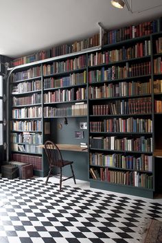 a room filled with lots of books on top of a black and white checkered floor