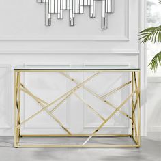 a glass and gold console table in a white room