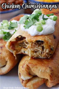 chicken enchiladas with sour cream and green onions on top are piled together