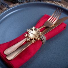 a blue plate topped with two forks and a red napkin