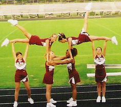 a group of cheerleaders doing stunts on the sidelines