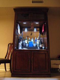 a wooden cabinet with liquor bottles in it