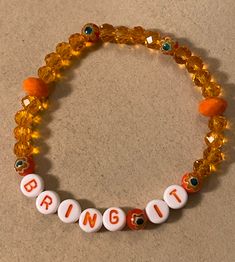 "Stretch Bracelet measures 7 3/8\" and reads BRING IT in white plastic with orange letters. You will feel empowered when you wear this bright orange stretchy bracelet! No matter the situation, you're ready, so BRING IT!  Twenty 6mm rondelle crystal beads in clear orange, five deeper orange 6mm Millefiori glass flower beads, and two 8mm opaque orange rondelle crystal glass beads make up this unique stretchy beaded EMPOWERMENT bracelet. Watch for more one of a kind ideas from my imagination, or op Casual Orange Stretch Bracelet With Letter Beads, Orange Stretch Bracelet With Letter Beads, Orange Bracelet, Feel Empowered, Resin Bracelet, My Imagination, Flower Beads, Stretchy Bracelets, Lovely Earrings