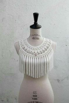 a white mannequin with fringes on it's chest and neckline