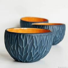 three blue and orange bowls sitting next to each other