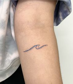 a person with a small wave tattoo on their arm