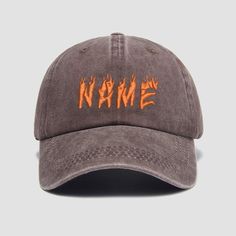 a gray hat with orange flames on the front and name in flame embroidered on the side