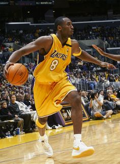 a basketball player dribbling the ball during a game with fans in the stands