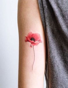 a woman's arm with a single red flower on the left side of her arm