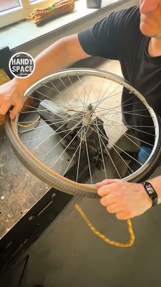 a man working on a bicycle wheel in a shop