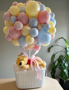 a teddy bear in a basket with balloons