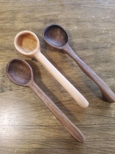 three wooden spoons sitting on top of a table