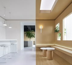 an empty room with stools and plants in the window sill next to each other