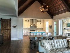 a living room filled with furniture next to a kitchen and dining room table in front of a window