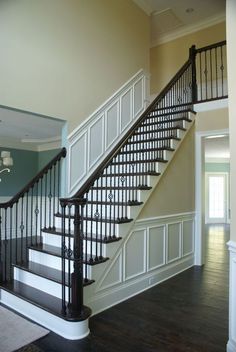 a staircase in a house with wood floors and white railings on either side of the stairs