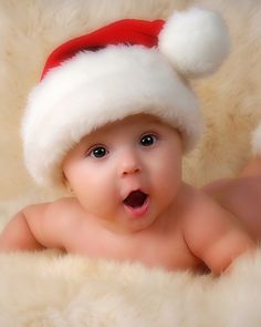 a baby wearing a santa hat laying down